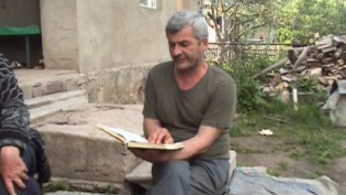 Speaker of Ossetic reading from a book